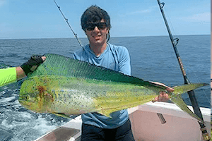 Happy Hatteras charter boat angler holding up a beautiful mahi he just caught.